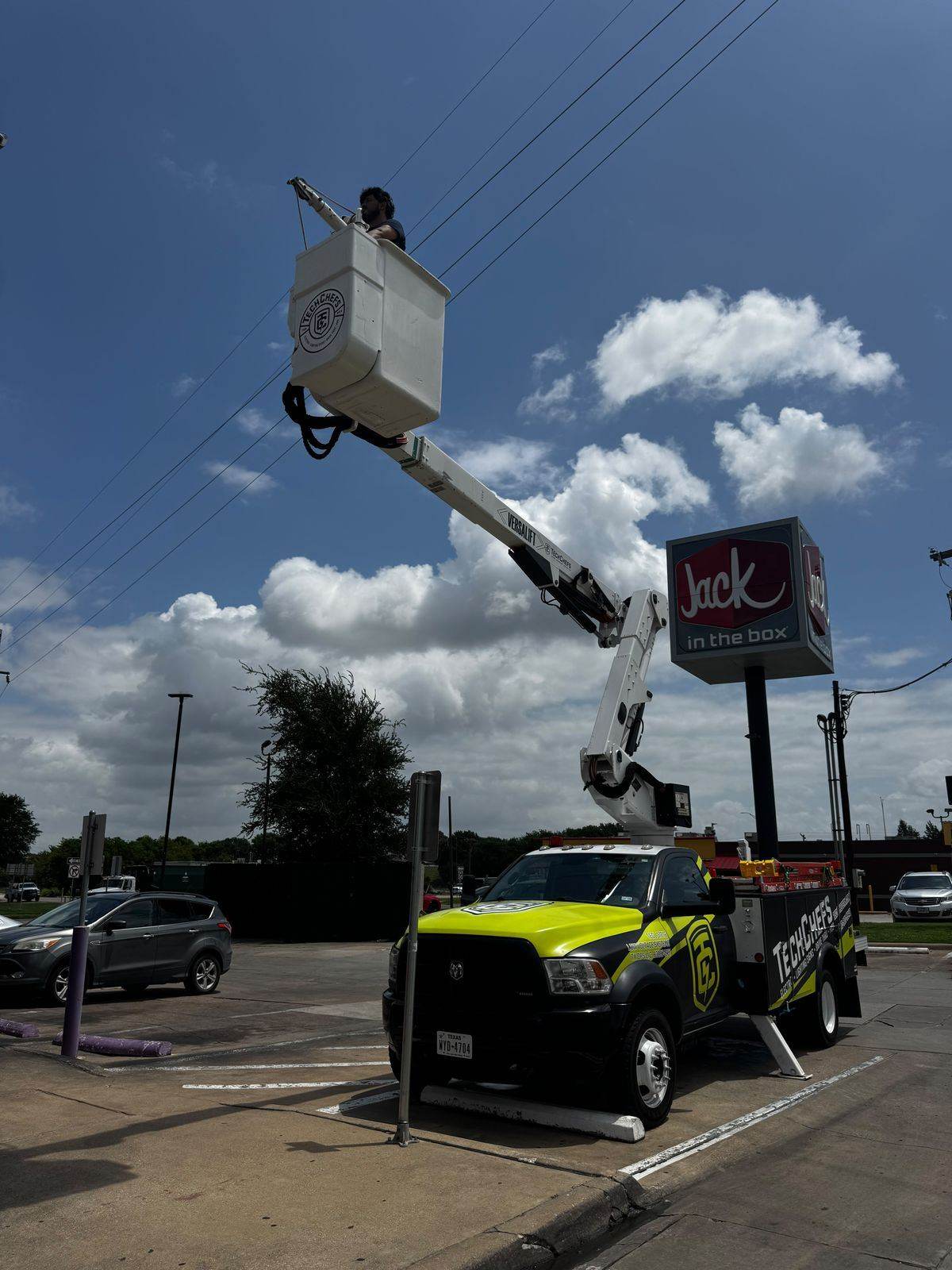 Tech Chefs bucket truck servicing a Jack in the Box sign