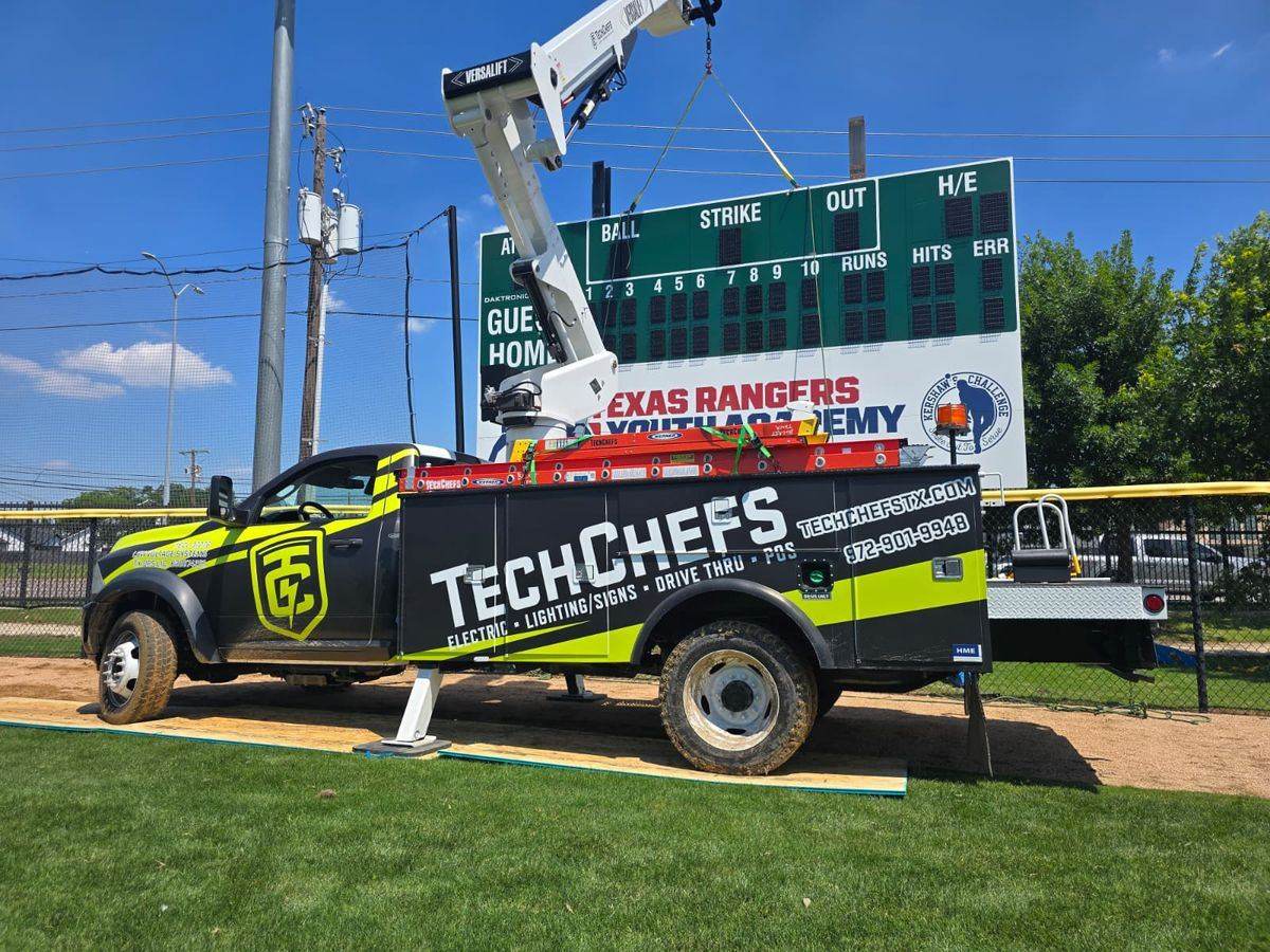 Tech Chefs crew servicing stadium lighting from a bucket lift